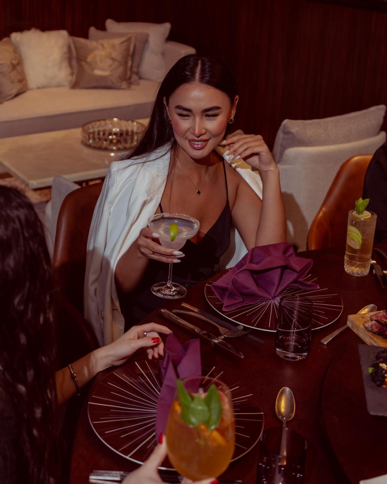 City Centre Rotana Doha Bagian luar foto A woman drinking a cocktail